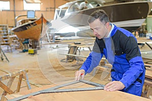 Shipwright measuring the plywood photo