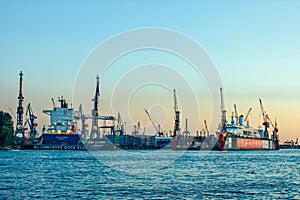 Shipyard and harbor shipbuilding with crane machine and container ship in Hamburg Germany