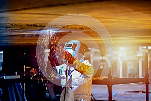 Shipyard Worker welding ship repair on dark tone.