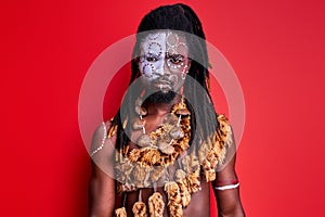 Shirtless african man with shaman aborigen make-up confidently looking at camera