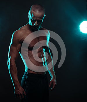 Shirtless Athletic Man Looking Down with Spotlight photo