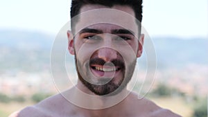 Shirtless athletic man smiling to camera