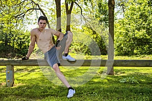 Shirtless athletic young man resting in city park