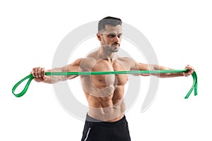 Shirtless bodybuilder holding resistance band.