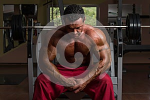 Shirtless bodybuilder resting at the bench