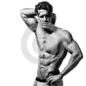 Shirtless bodybuilder showing his muscular arms.
