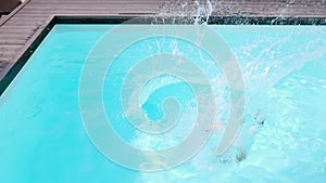 Shirtless boy jumping into swimming pool