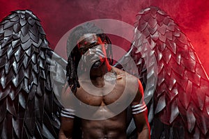 Shirtless dark angel in red smoky space