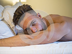 Shirtless male model lying alone on his bed