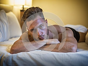 Shirtless male model lying alone on his bed