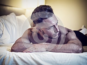 Shirtless male model lying alone on his bed