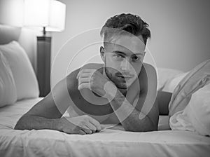 Shirtless male model lying alone on his bed