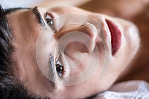 Shirtless male model lying alone on his bed