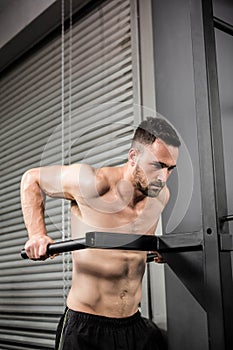 Shirtless man doing pull up