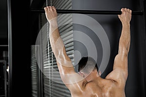 Shirtless man doing pull up