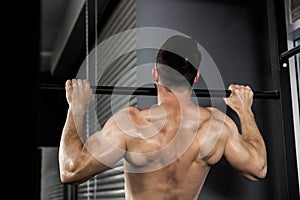 Shirtless man doing pull up photo