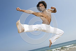 Shirtless Man Jumping On Beach