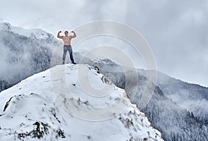 Shirtless man in the mountains winter time