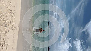 Shirtless man walking towards sea for swimming during summer