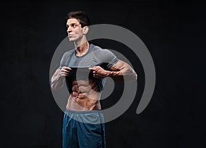 Shirtless muscular male over dark background.