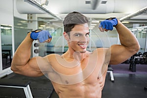 Shirtless muscular man flexing muscles in gym