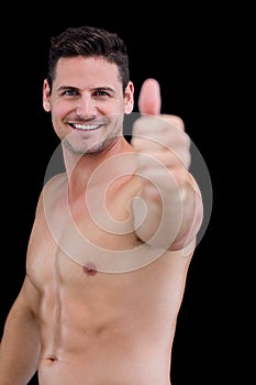 Shirtless muscular man giving thumbs up