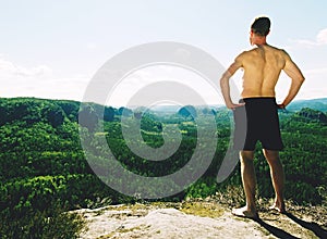 Shirtless tall caucasian man wear black shorts rests on mountain peak