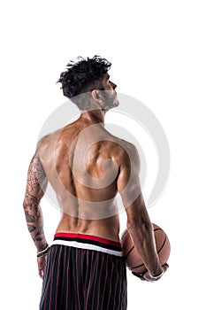 Shirtless young man holding basketball ball