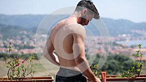 Shirtless Young Man Looking at his Peeling Skin