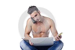 Shirtless young man overwhelmed by technology: PC, tablet, phones