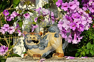 Shisa figure and pink flowers