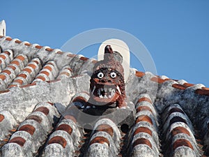 Shisa lion dog guardian on a traditional tile roof in Okinawa, Japan