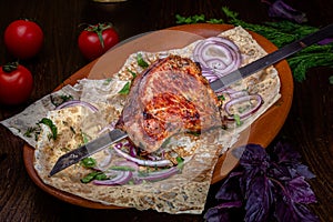 Shish kebab of beef, pork or lamb on a skewer lies on a plate in a restaurant