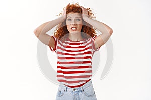 Shit woman trouble. Attractive worried puzzled and concerned young redhead curly woman grab head panic clench teeth look