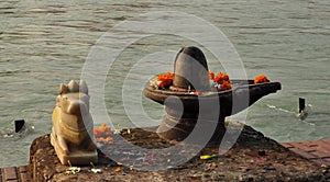 Shiva Linga and sacred bull statue on the Ganges river bank