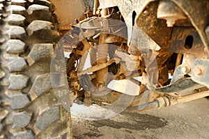 Shock Absorbers and Brake Pad in undercarriage of bigfoot car is stain of muddy soil