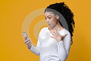Shock Content. Dazed African American Woman Looking At Smartphone Screen