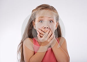 Shock, portrait and hands over mouth, girl kid with reaction and unexpected news with surprise on white background