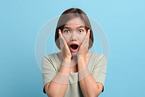 Shock / surprise and wow concept. Portrait of shocked asian woman open mouth being surprised or astonished to see large discounts