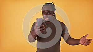 Shocked african american black man looking at the screen of his phone. Unexpected text message or bad news