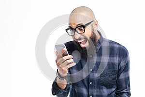 Shocked african american man using mobile phone and shouting