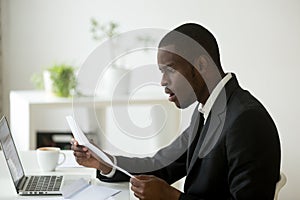 Shocked African American reading received printed documentation