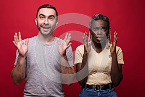 Shocked African American young female and male look with scared frightened expressions at camera, cover mouth, being stunned to