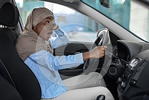 Shocked african muslim woman having car accident, her auto hit by another vehicle