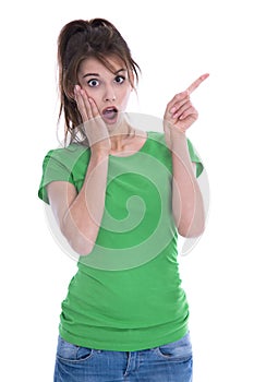 Shocked and amazed young woman in green shirt pointing with her