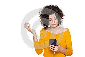 Shocked angry young girl looking at her mobile phone in disbelief. Teenager staring at shocking text message on her phone.