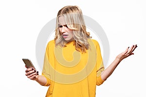 Shocked angry young woman looking at her mobile phone in disbelief. Woman staring at shocking text message on her phone.