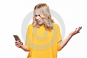 Shocked angry young woman looking at her mobile phone in disbelief. Woman staring at shocking text message on her phone. photo