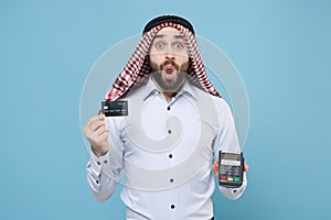 Shocked arabian muslim man in keffiyeh kafiya ring igal agal isolated on pastel blue background. People religious