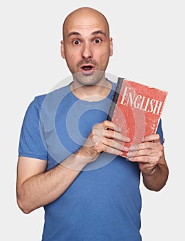 Shocked bald man holds an English textbook